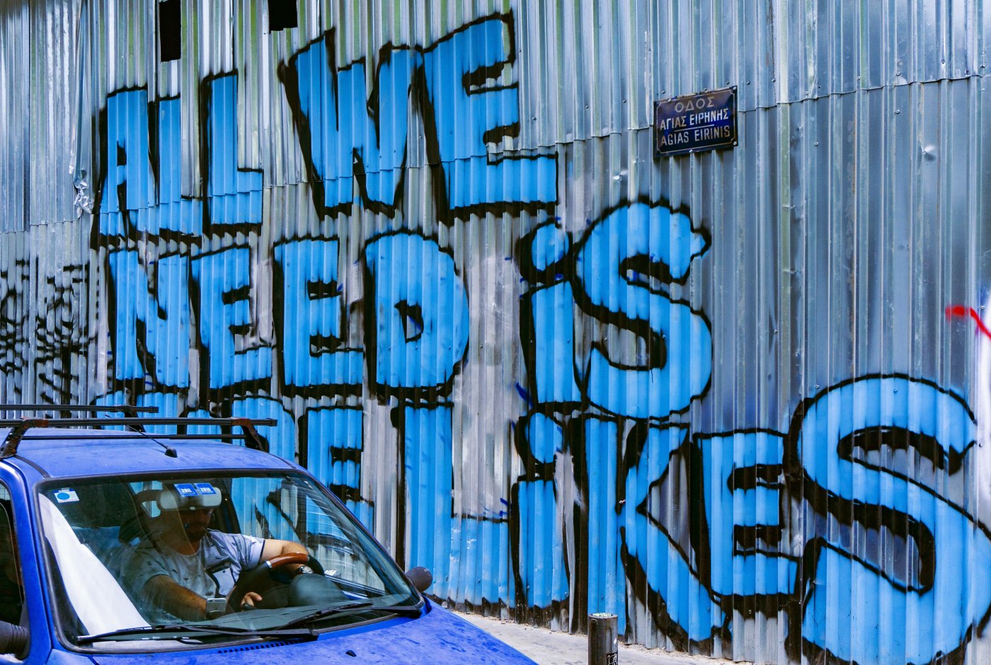 graffiti text on a metal wall "all we need is more likes"