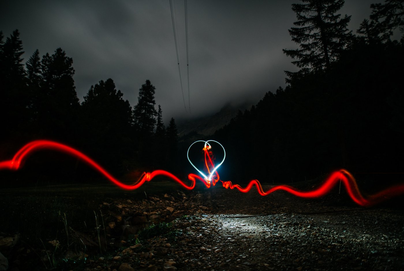 a heart and red light with a dark road behind
