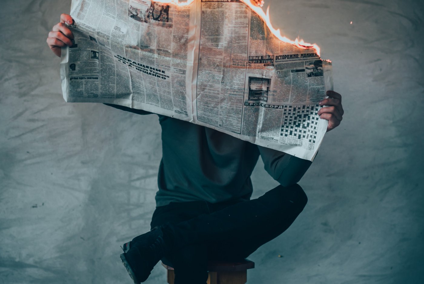a man reading a newspaper in flames