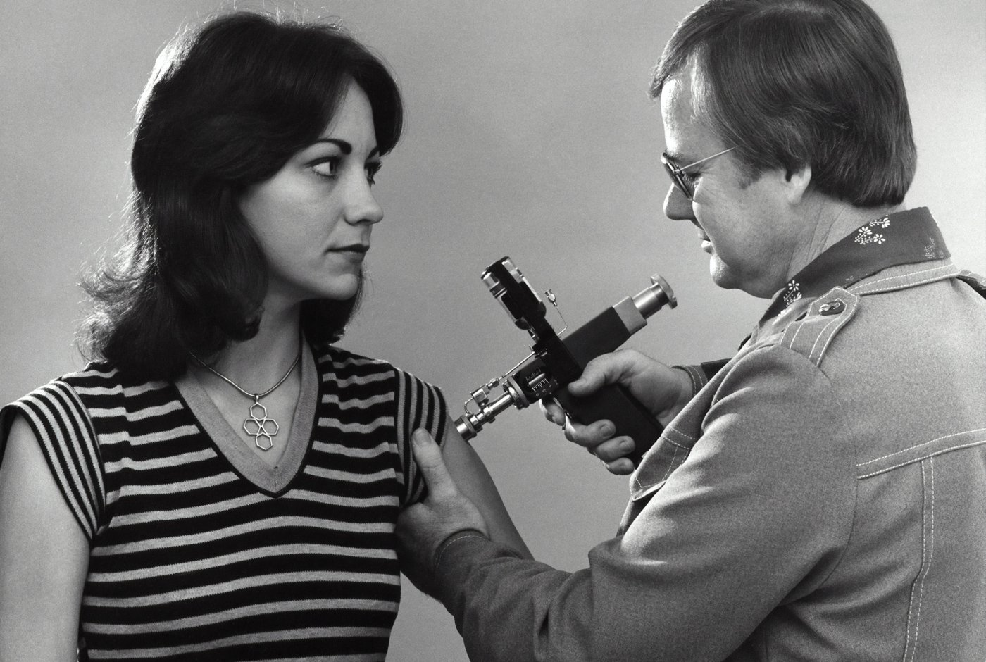 an adult female receiving a vaccination administered by a clinician