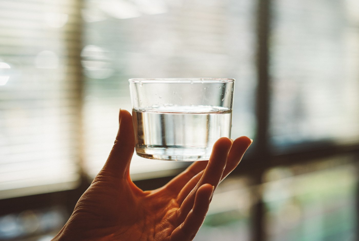 a hand with a glass of water
