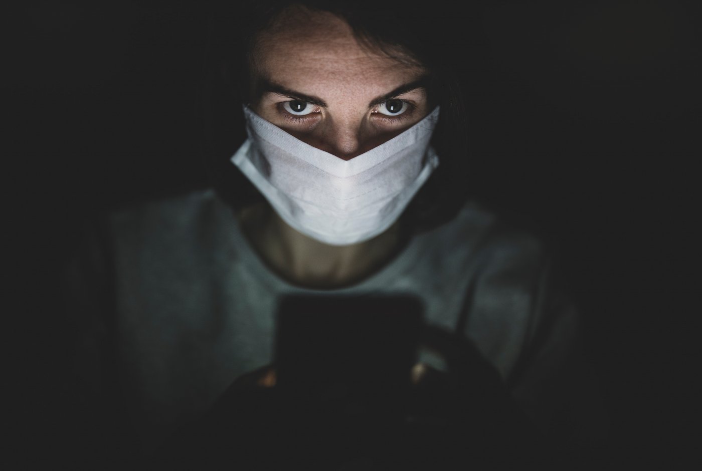 a person staring with a mask on and a smart phone
