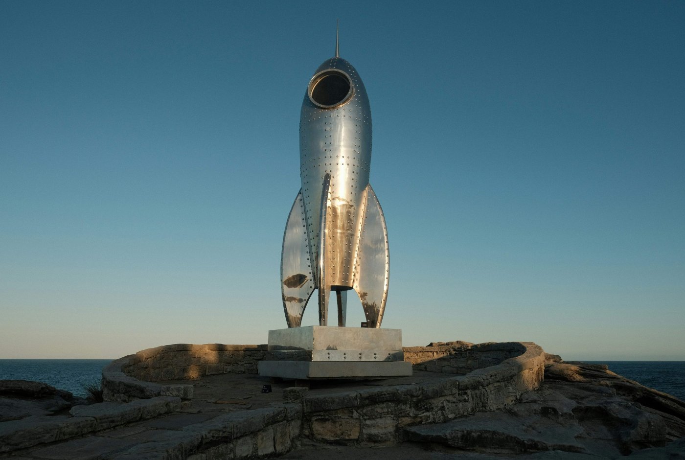 Statue of a rocket on top of a rock