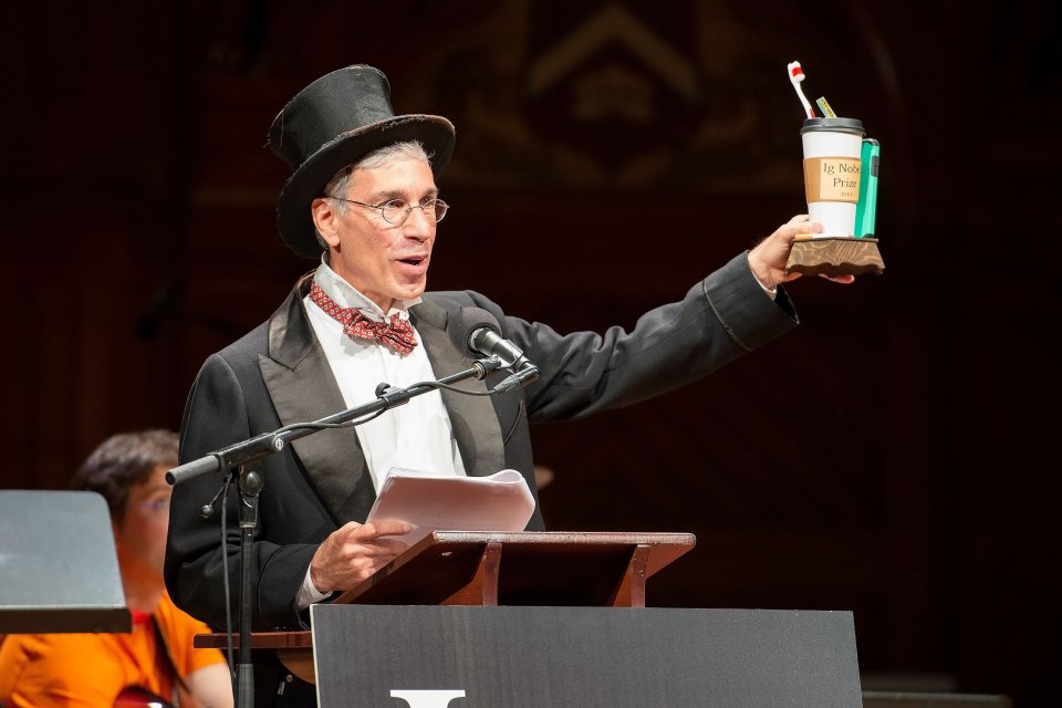 a man with a top hat raising a prize a a podium