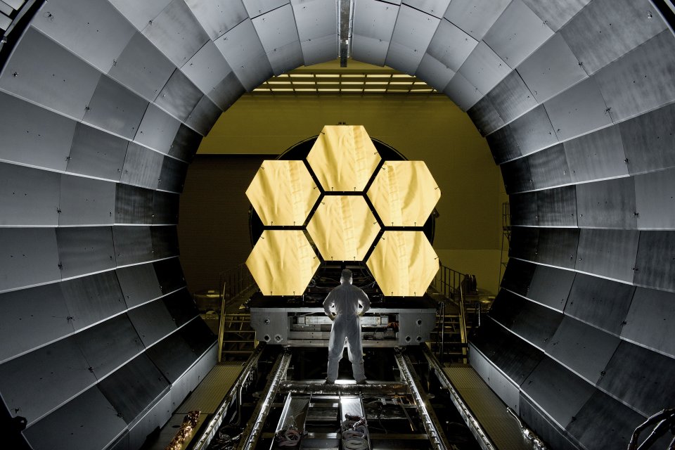 An engineer looks on as the first six flight ready James Webb Space Telescope's primary mirror segments