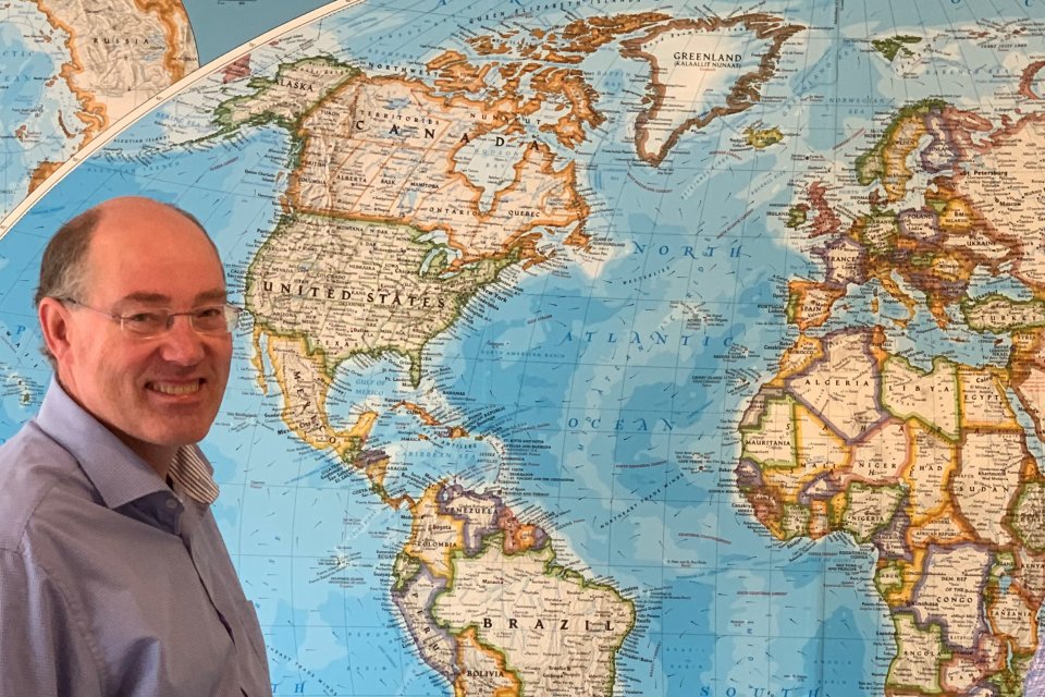 Carsten Rahbek in front of a world map
