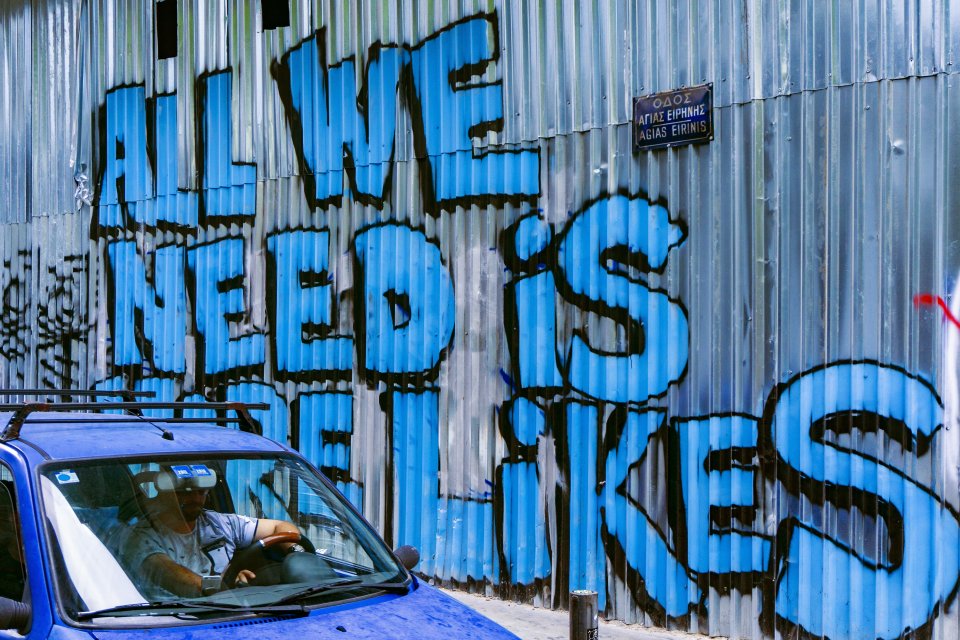 graffiti text on a metal wall "all we need is more likes"