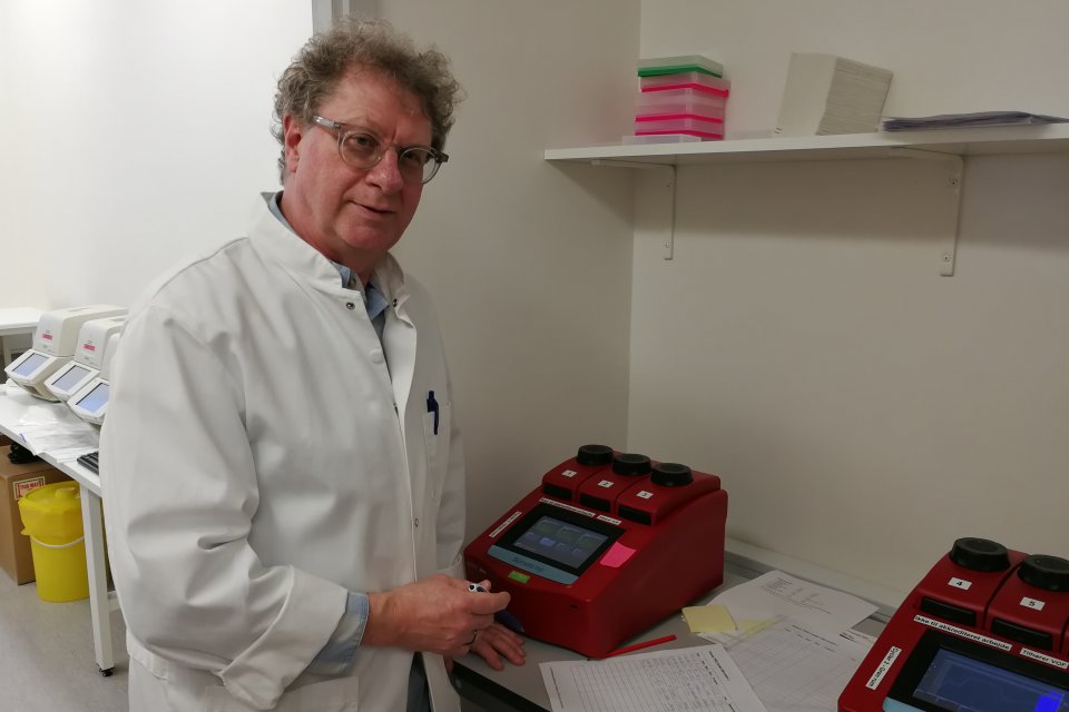 A man in a white robe doing tests