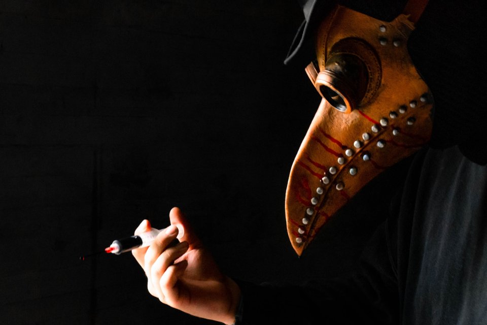 a masked person with a syringe