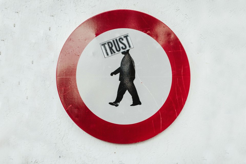 traffic sign with man and word 'trust' 