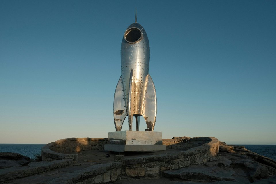 Statue of a rocket on top of a rock